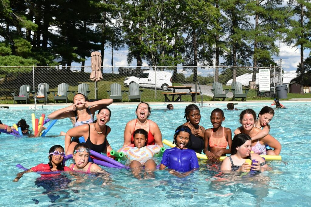 Girls in the swimming pool at grief camp being silly