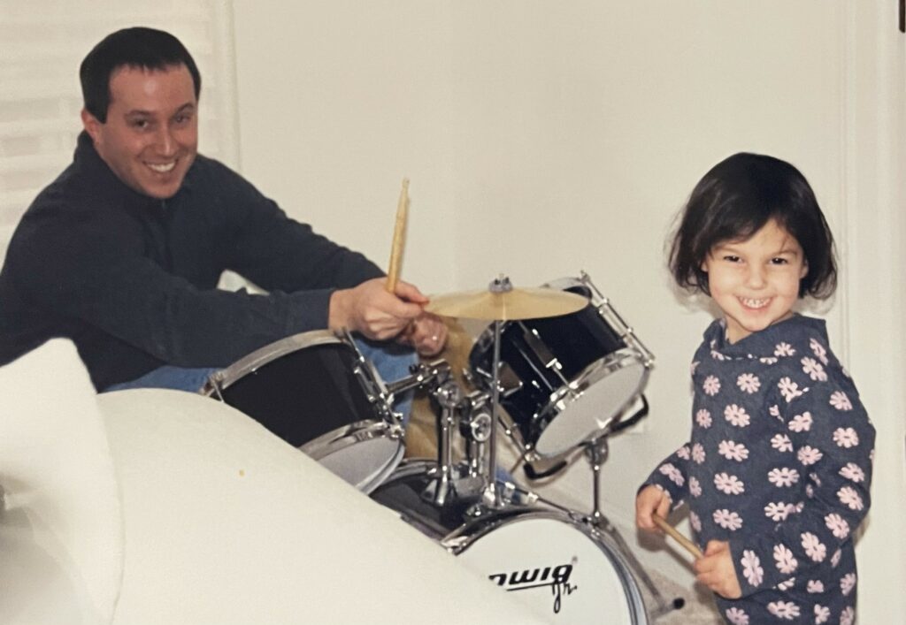 Betsy with her dad, who is playing drums