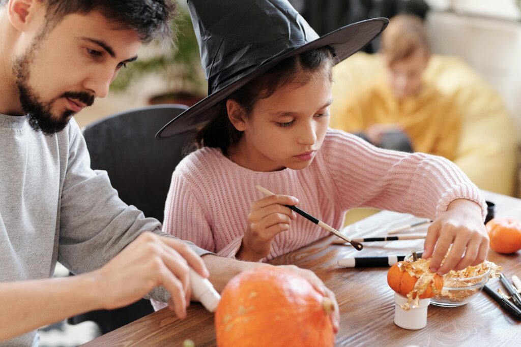 Parent and child painting pumpkin