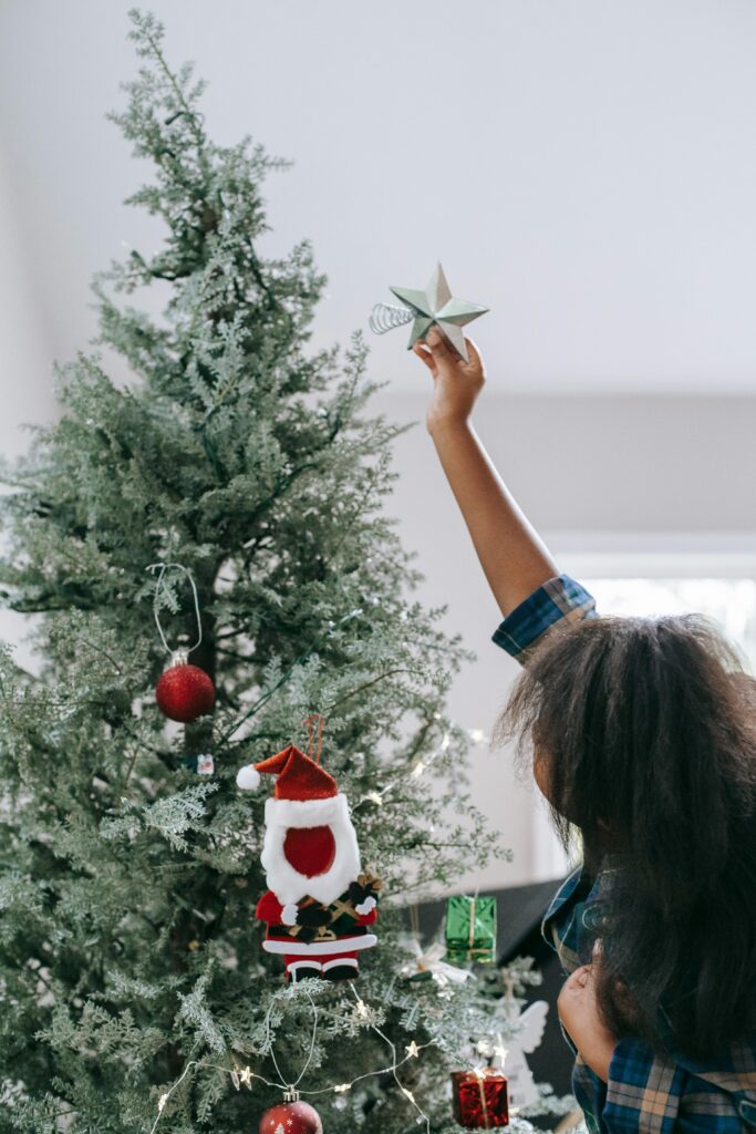 Teen putting ornament on Christmas tree